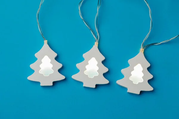 Christmas Tree Shape Light Garland Blue Paper Background — Stock Photo, Image