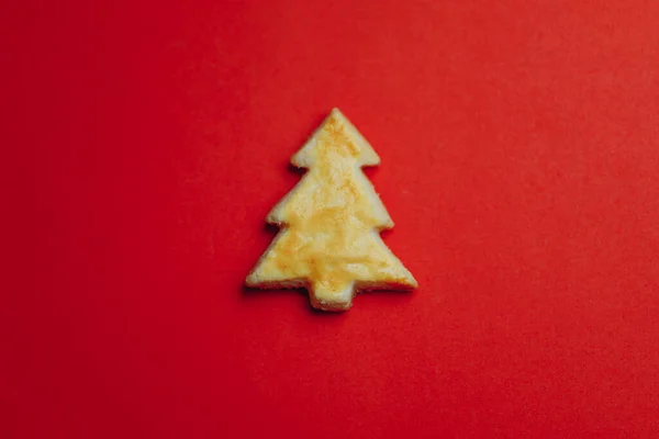 赤い紙の背景にクリスマスツリークッキー — ストック写真