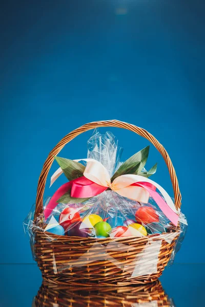 Pasen Geschenkmand Met Veelkleurige Eieren Blauwe Achtergrond — Stockfoto