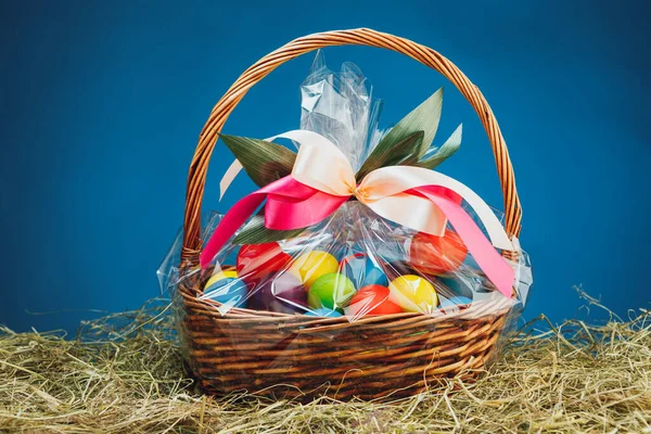 Velikonoční Dárkový Koš Vícebarevnými Vejci Modré Pozadí — Stock fotografie