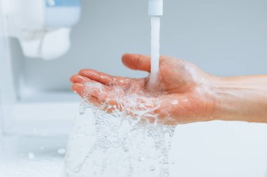 Musluğun altında akan suyla.