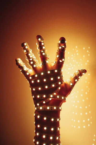 Menselijke Hand Bedekt Met Oranje Led Verlichting Verlichte Achtergrond — Stockfoto