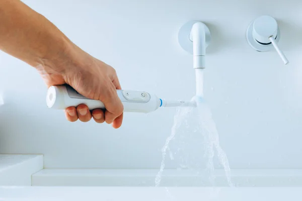 Mano Sosteniendo Cepillo Dientes Bajo Agua Que Fluye Del Grifo —  Fotos de Stock