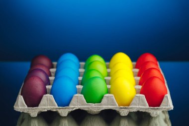 Paskalya bayramı çok renkli yumurta kutusu, mavi arkaplan ve fotokopi alanı