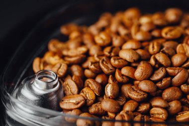 Kahve makinesindeki kahve çekirdekleri, yakın çekim görüntüsü.