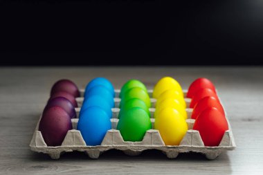 Paskalya bayramı çok renkli yumurta kutusu, siyah fotokopi alanı arka planı