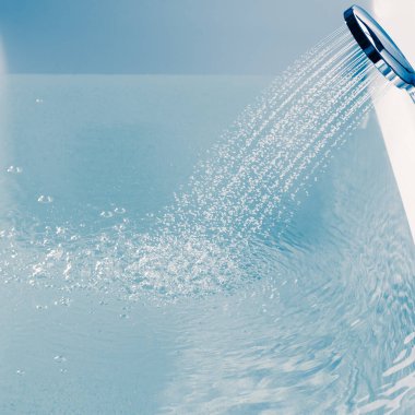 Küveti suyla dolduran bir duş.