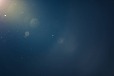 parlak parçacıklar ve mercek parlamaları ile soyut mavi ışık arkaplanı