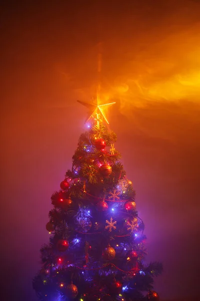 Kerstboom Met Feestelijke Lichtjes Oranje Achtergrond Met Rook — Stockfoto