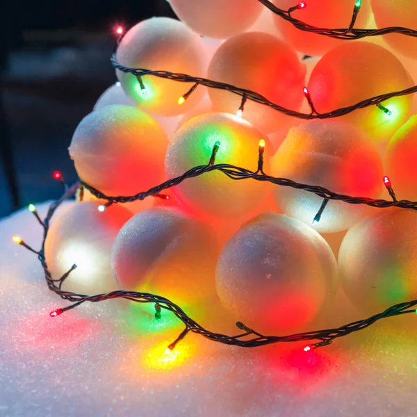 snowballs heap with festive garland led lights, close-up view