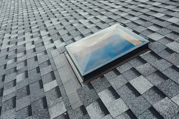 roof of new house with shingles roof-tiles and ventilation window