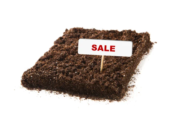 Morceau de terre avec titre de vente, isolé sur blanc — Photo