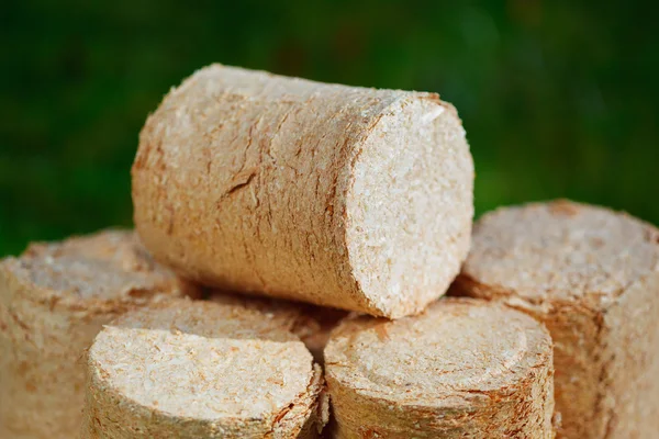 Pellets de madera sobre fondo de hierba verde — Foto de Stock