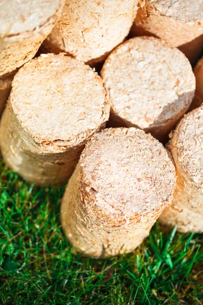 Holzpellets auf grünem Gras Hintergrund — Stockfoto