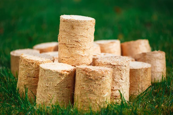 Pellets de madera sobre fondo de hierba verde — Foto de Stock