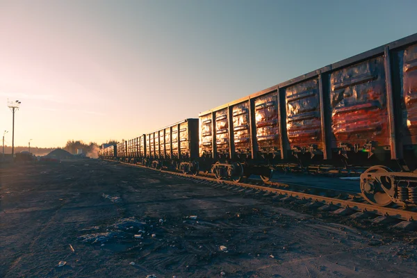 Goederentrein goederenwagons bij zonsopgang — Stockfoto