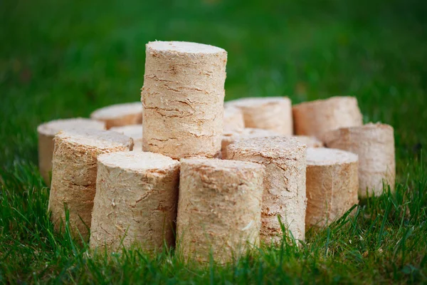 Wooden pellets on green grass background — Stock Photo, Image