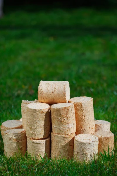 Pellets de madera sobre fondo de hierba verde — Foto de Stock