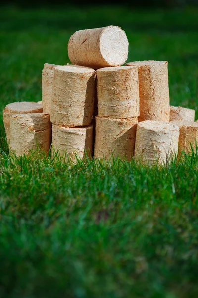 Pellets de madera sobre fondo de hierba verde — Foto de Stock