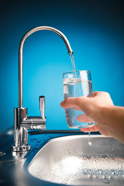 Hand pouring a glass of water from filter tap — Stock Photo, Image