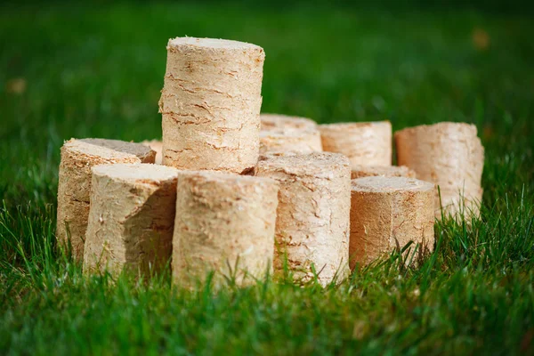 Pellet di legno su sfondo verde erba — Foto Stock