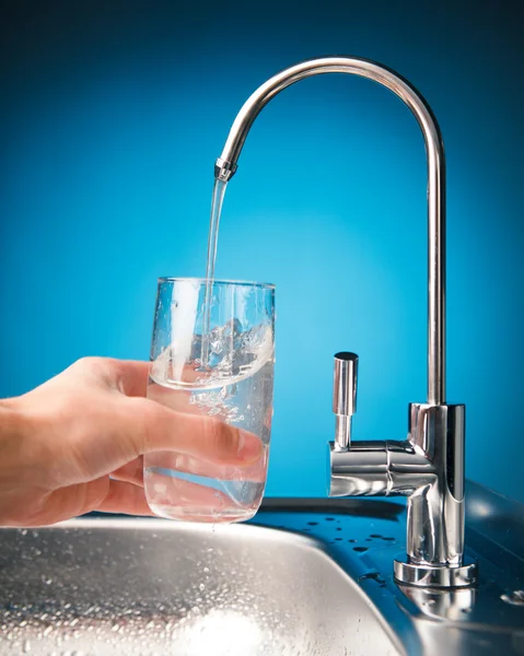 Hand pouring a glass of water from filter tap — Stock Photo, Image