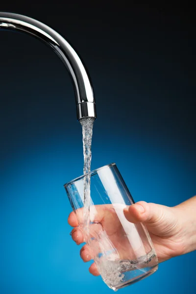 Dłoń wylewająca szklankę wody z kranu filtra — Zdjęcie stockowe