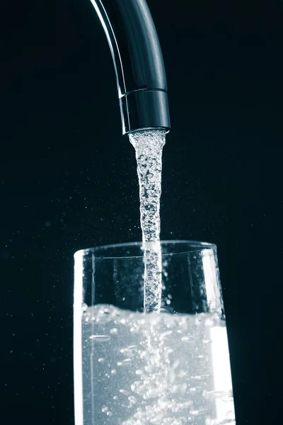 Versare un bicchiere d'acqua dal rubinetto del mixer — Foto Stock