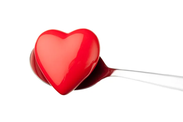 Corazón rojo sobre cuchara aislada sobre blanco — Foto de Stock