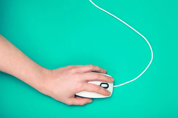 Hand on computer mouse, emerald background — Stock Photo, Image