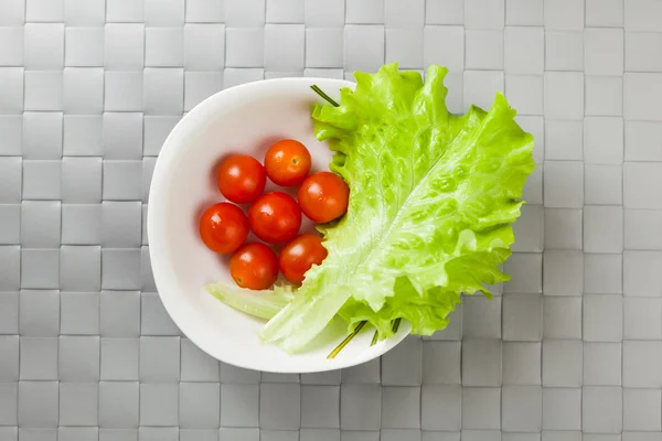 Verdure fresche su piatto, posto grigio sfondo opaco — Foto Stock