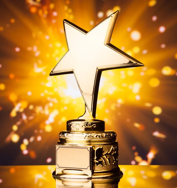 Gold star trophy against shiny sparks background — Stock Photo, Image