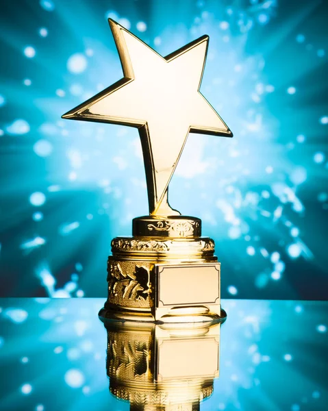 Трофей золотой звезды на фоне синих искр — стоковое фото