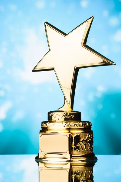 Gold star trophy against blue sparks background — Stock Photo, Image