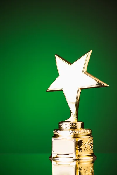 Gold star trophy against green background — Stock Photo, Image