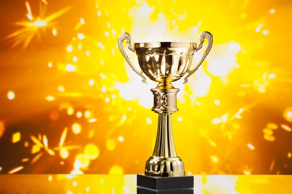 Troféu copo de ouro contra faíscas brilhantes fundo — Fotografia de Stock