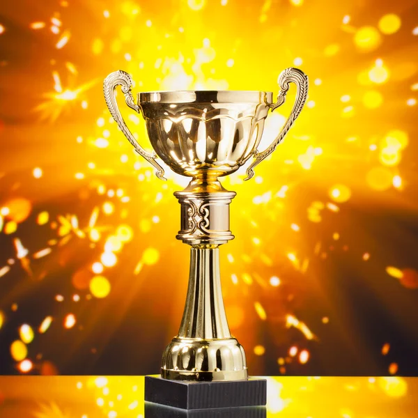Gold cup trophy mot blanka gnistor bakgrund — Stockfoto