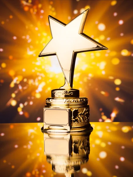 Troféu estrela de ouro contra faíscas brilhantes fundo — Fotografia de Stock