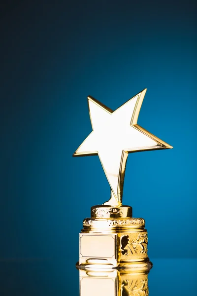 Трофей золотой звезды на синем фоне — стоковое фото