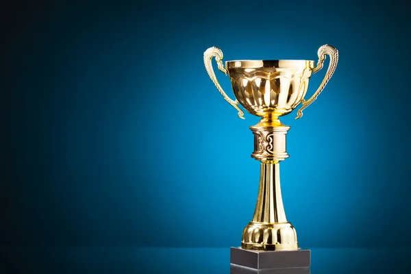 Gold cup trophy on blue background — Stock Photo, Image