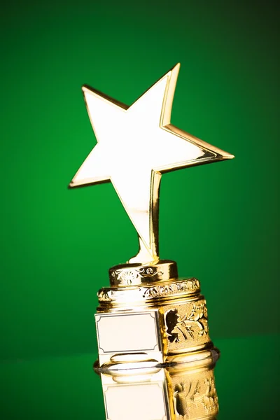 Troféu estrela de ouro contra fundo verde — Fotografia de Stock