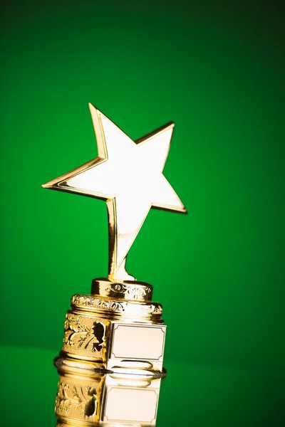 Troféu estrela de ouro contra fundo verde — Fotografia de Stock