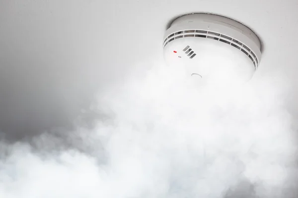 Smoke detector of fire alarm in action, white background — Stock Photo, Image