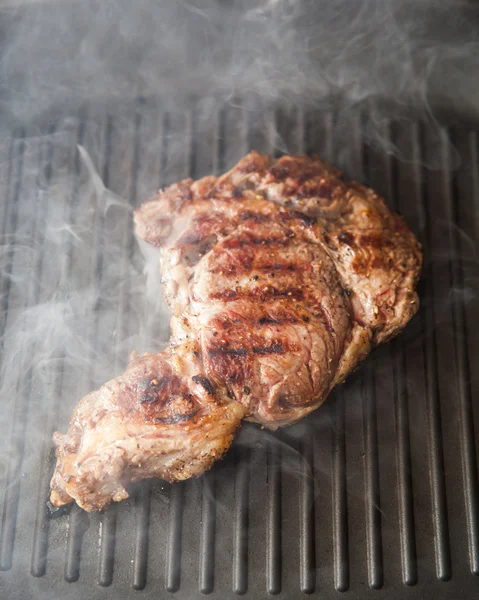 Frying beef steak on a ribbed grill pan — Stock Photo, Image