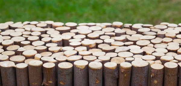 Wooden cuts against green lawn background — Stock Photo, Image