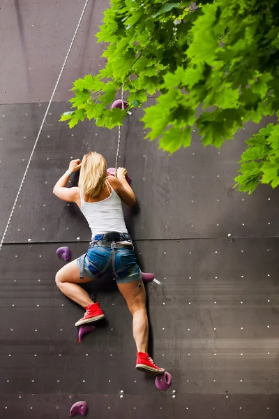 Mulher escalada parede de rocha artificial — Fotografia de Stock