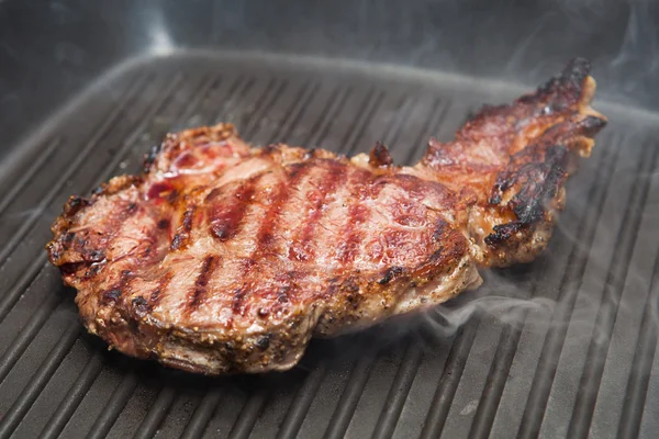 Frying beef steak on a ribbed grill pan — Stock Photo, Image