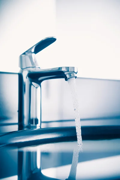 Wasserhahn mit fließendem Wasser, blauer Ton — Stockfoto