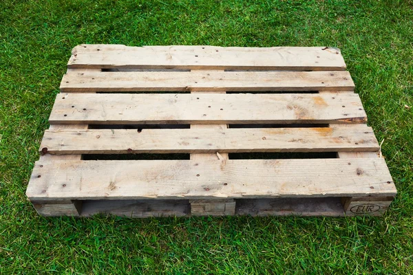 Leeg pallet op groen gras — Stockfoto