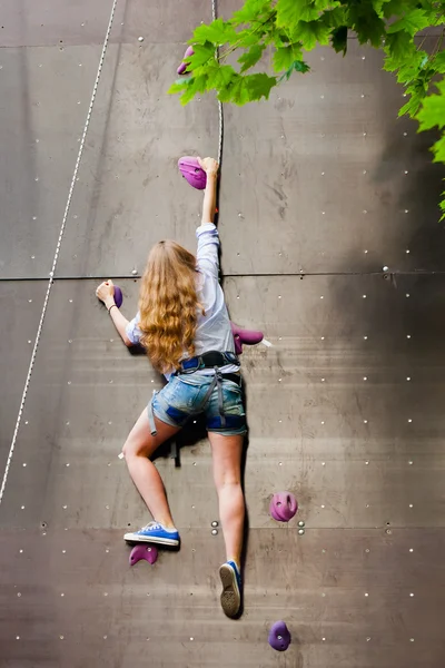 Donna arrampicata parete di roccia artificiale — Foto Stock